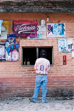 A Mexican man standing at the window of a store in San Miguel de Allende, Mexico Stock Photo - Rights-Managed, Code: 862-03712882