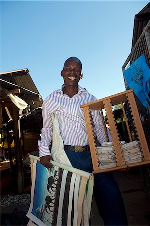 simsearch:862-06543210,k - Malawi, Zomba. In the market, a smiling  Entrepreneur walks around the market selling his African artwork Stock Photo - Rights-Managed, Code: 862-03713051