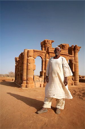 sudan - Sudan, Nagaa. The solitary guide at the remote ruins of Nagaa stands in front of the ruins. Stock Photo - Rights-Managed, Code: 862-03713648