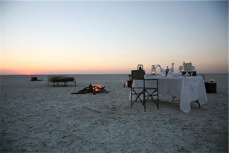 Botswana, Makgadikgadi. A romantic dinner for two is set up at sunset on the empty Makgadikgadi saltpans. Stock Photo - Rights-Managed, Code: 862-03736364