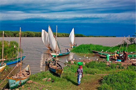 simsearch:862-03821015,k - Kenya, Nyanza District. Fishermen return in their boats from fishing in Lake Victoria while women prepare to sell the catch Foto de stock - Con derechos protegidos, Código: 862-03736810