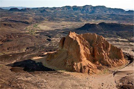simsearch:862-03820284,k - Un volcan éteint ruine, connu comme Aruba Rock, est entouré par les sorties de la roche de lave noire sur le bord de la vallée de Suguta. Photographie de stock - Rights-Managed, Code: 862-03736867