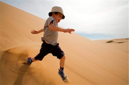 simsearch:862-03365353,k - Skeleton Coast, Namibia. A young boy runs in the Namib Desert on a safari operated by Turnstone Tours from Swakopmund. Stock Photo - Rights-Managed, Code: 862-03737007