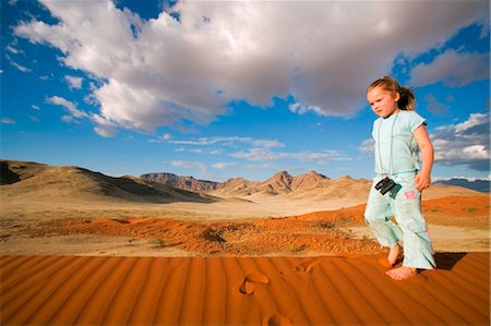 simsearch:862-03365353,k - Namib Rand Nature Reserve, Namibia. A young boy runs across the rippled surface of a sand dune in the Namib Desert. Stock Photo - Rights-Managed, Code: 862-03737002
