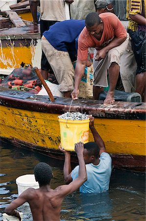 simsearch:862-03821015,k - Tanzania, Zanzibar, Stone Town. A busy scene at Zanzibars dhow harbour as fish are sold by fishermen direct from their boat. Foto de stock - Con derechos protegidos, Código: 862-03737312