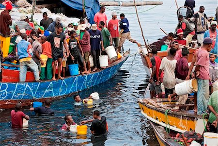 Tanzania, Zanzibar, Stone Town. A busy scene at Zanzibars dhow harbour as fish are sold by fishermen direct from their boat. Stock Photo - Rights-Managed, Code: 862-03737313