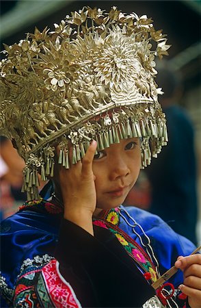 China, Guizhou Province, nr. Kaili, Langde. A Miao (or Hmong) girl wears a traditional silver-alloy headdress Stock Photo - Rights-Managed, Code: 862-03731132