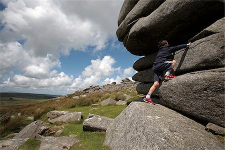 England, Cornwall, Bodmin Moor. Boy climbing on the Cheesewrings granite tors. Stock Photo - Rights-Managed, Code: 862-03731248