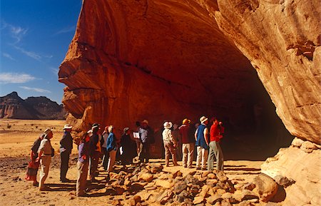 paint art of africa - Libya, Fezzan, Jebel Akakus. Tourists gather at the mouth of Uan Amil, one of Wadi Teshuinat's caves. Stock Photo - Rights-Managed, Code: 862-03731756