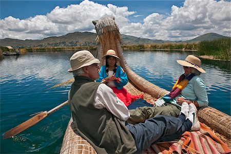 rower girls - Peru, Tourists being rowed in a traditional reed boat around the unique floating islands of Uros on Lake Titicaca. Stock Photo - Rights-Managed, Code: 862-03732108