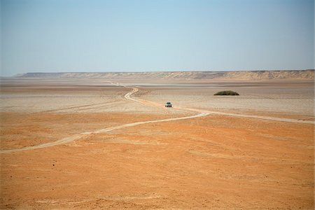 Ghadames, Libya; A vast view of the Ghadames desert with a car dwarfed by its surroundings and low mountains in the background Stock Photo - Rights-Managed, Code: 862-03807859