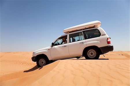 dune driving - Oman, Wahiba Sands. A 4x4 eases over a sand dune in the midday sun. Stock Photo - Rights-Managed, Code: 862-03808148