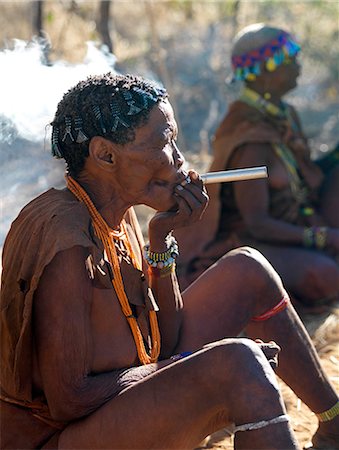 simsearch:862-03820241,k - A band of NIIS hunter gatherers enjoy a smoke having collected several baobab fruits, which they will use as food.The pith surrounding the seeds can be made into an appetising drink.The NIIS are a part of the San people, often referred to as Bushmen. Stock Photo - Rights-Managed, Code: 862-03820234