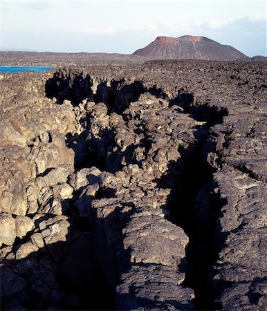 A little distance offshore from the coast of Djibouti, the northern extent of Africas Great Rift Valley abuts a triple junction where the oceanic rifts of the Red Sea and the Gulf of Aden converge.This photograph shows an obvious crack in a huge lava ridge.Other than Iceland, Djibouti is the only country where scientists can observe the sea floor spreading on dry land as two plates move apart. Stock Photo - Rights-Managed, Code: 862-03820284