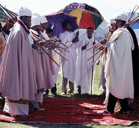 simsearch:862-03353978,k - Ethiopian Orthodox priests perform the Dance of the Priests to celebrate Timkat, the churchs most important Holy Day. Ethiopia is Africas oldest Christian nation where more than half the population follows the Ethiopian Orthodox faith. During Timkat, priests stand in two rows, facing one another and sway gently as they chant. Attendants hold silk brocade umbrellas to shade them from the sun Stock Photo - Rights-Managed, Code: 862-03820368