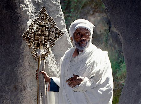 simsearch:862-03353978,k - An old Ethiopian Orthodox priest holds a large brass Coptic cross at the rock hewn church of Adadi Maryam, just south of Addis Abeba. This is the southernmost of Ethiopias rock hewn churches. Stock Photo - Rights-Managed, Code: 862-03820411