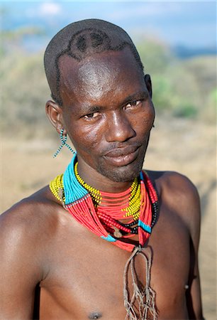 face of a tribal man - A Hamar man with an unusual hairstyle attends a Jumping of the Bull ceremony.The semi nomadic Hamar of Southwest Ethiopia embrace an age grade system that includes several rites of passage for young men.The most elaborate of them and the most important is the Jumping of the Bull ceremony. Stock Photo - Rights-Managed, Code: 862-03820524