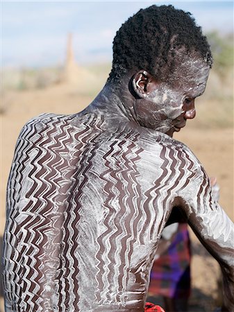 simsearch:862-03820434,k - Hommes Nyangatom décorent eux-mêmes avec la craie blanche, rock pulvérisé ou autres pigments naturels avant une danse.Le Nyangatom sont une des plus grandes tribus et sans doute les plus belliqueuses de personnes vivant le long de la rivière Omo en Éthiopie. Photographie de stock - Rights-Managed, Code: 862-03820537
