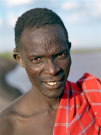 simsearch:862-03820434,k - Un homme Nyangatom avec scarification du visage.Le Nyangatom sont une des plus grandes tribus et sans doute les plus belliqueuses de personnes vivant le long de la rivière Omo en Éthiopie. Ils forment une partie du peuple francophone Ateger un groupe de sept tribus nilotiques orientales auquel appartiennent les Turkana du Kenya du Nord et les Karamajong du nord-est de l'Ouganda. Photographie de stock - Rights-Managed, Code: 862-03820540