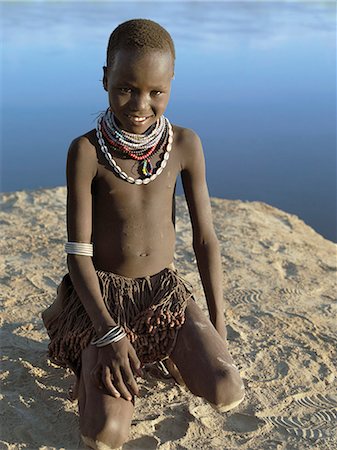 simsearch:862-03711116,k - A young Nyangatom girl on the banks of the Omo River.The Nyangatom are one of the largest tribes and arguably the most warlike people living along the Omo River in Southwest Ethiopia. They form a part of the Ateger speaking people a cluster of seven eastern Nilotic tribes to which the Turkana of Northern Kenya and the Karamajong of Eastern Uganda belong. Foto de stock - Con derechos protegidos, Código: 862-03820542