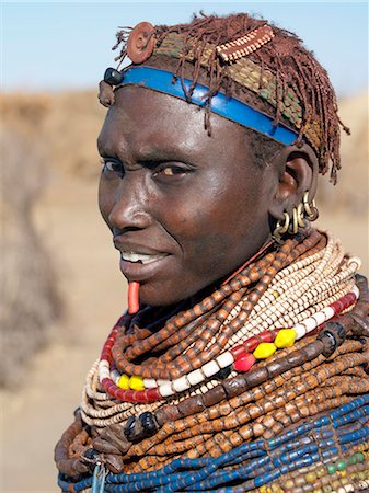 simsearch:862-03820434,k - Une femme de Nyangatom porte de nombreux brins de perles en bois.Le Nyangatom sont une des plus grandes tribus et sans doute les plus belliqueuses de personnes vivant le long de la rivière Omo en Éthiopie. Ils forment une partie du peuple francophone Ateger un groupe de sept tribus nilotiques orientales auquel appartiennent les Turkana du Kenya du Nord et les Karamajong du nord-est de l'Ouganda. Photographie de stock - Rights-Managed, Code: 862-03820552