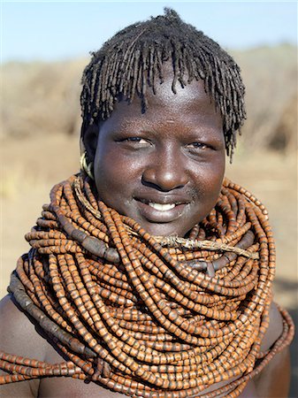simsearch:862-03820434,k - Une femme de Nyangatom porte de nombreux brins de perles en bois.Le Nyangatom sont une des plus grandes tribus et sans doute les plus belliqueuses de personnes vivant le long de la rivière Omo en Éthiopie. Ils forment une partie du peuple francophone Ateger un groupe de sept tribus nilotiques orientales auquel appartiennent les Turkana du Kenya du Nord et les Karamajong du nord-est de l'Ouganda. Photographie de stock - Rights-Managed, Code: 862-03820553