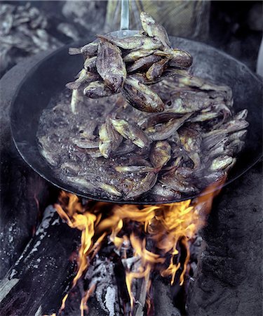 smoked - Small tilapia fish caught in Lake Rukwa, Southwest Tanzania, are deep fried before being sent to market in Mbeya, the commercial centre of the fertile Southern Highlands region.Lake Rukwa is a long, narrow lake lying in a basin of inland drainage southeast of Lake Tanganyika. Stock Photo - Rights-Managed, Code: 862-03821015