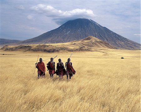 simsearch:862-03355162,k - Maasai warriors stride across the golden grass plains at the foot of Ol doinyo Lengai, the Maasais Mountain of God. Ol doinyo Lengai is the only active volcano in the Gregory Rift, an important section of the eastern branch of Africas Great Rift Valley system that stretches from northern Kenya into Northern Tanzania. Foto de stock - Con derechos protegidos, Código: 862-03821011