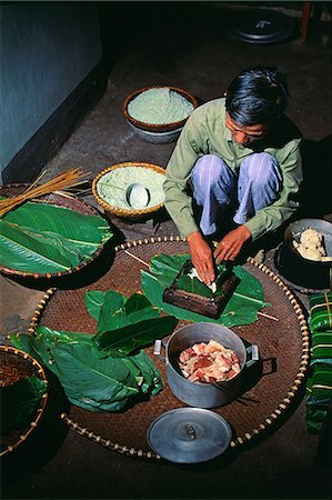 Making Sticky Rice cakes in preparation for Vietnamese New Year.Sticky rice cakes are a Vietnamese traditional dish that must be part of Tet meals.Every Vietnamese family must have sticky rice cakes among the offerings placed on the altar to their ancestors. Stock Photo - Rights-Managed, Code: 862-03821051