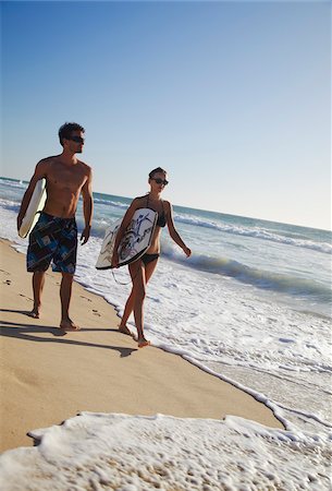 Jeune couple marchant sur la plage de Brighton avec planches de surf horizontal, Perth, Western Australia, Australie Photographie de stock - Rights-Managed, Code: 862-03887243
