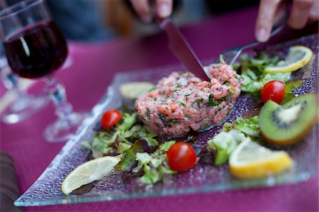 A diner cutting into steak tartare in a restaurant in paris France Stock Photo - Rights-Managed, Code: 862-03887708