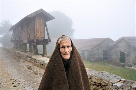 Woman of Paredes do Rio, in Peneda Geres National Park, Tras os Montes, Portugal. In the background, a 'espigueiro', traditional granary of this region. Stock Photo - Rights-Managed, Code: 862-03889065