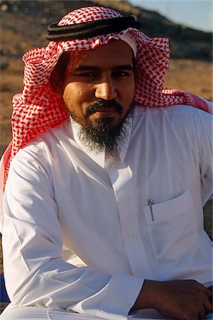 saudi arabia people - Saudi Arabia.  A Saudi man wearing his traditional clothes - a white cotton thawb with a headress comprising a white tagia (a skullcap) and a ghutra (red-checked square of cloth) held in place with an iqal (doubled black cord). Stock Photo - Rights-Managed, Code: 862-03889528