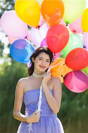 simsearch:877-06834306,k - Young woman holding bunch of balloons Stock Photo - Rights-Managed, Code: 877-06834294