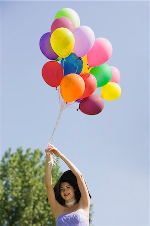 simsearch:877-06834306,k - Young woman holding bunch of balloons Stock Photo - Rights-Managed, Code: 877-06834291