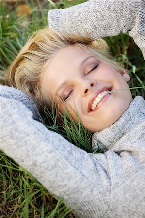 simsearch:877-06832318,k - Woman smiling, eyes closed, lying in the grass Stock Photo - Rights-Managed, Code: 877-06836073