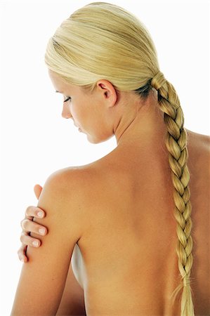 Backview of a blond haired woman with plait, hand on her arm Stock Photo - Rights-Managed, Code: 877-06836311