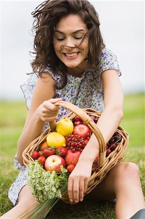 simsearch:877-06832290,k - Young woman with a basket full of fruits Stock Photo - Rights-Managed, Code: 877-06832274