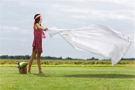 simsearch:877-06832290,k - Young woman setting a sheet on the grass, oudoors Stock Photo - Rights-Managed, Code: 877-06832306