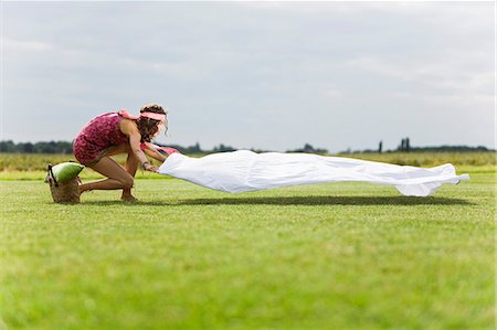 simsearch:877-06832318,k - Young woman setting a sheet on the grass, oudoors Stock Photo - Rights-Managed, Code: 877-06832308