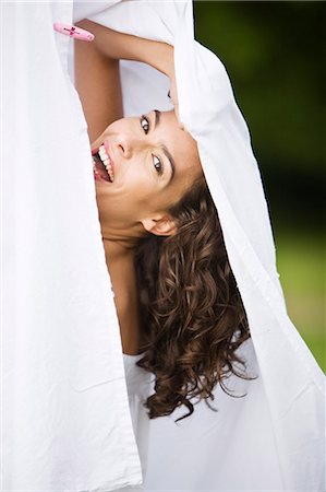 simsearch:877-06832290,k - Young woman laughing, behind a white sheet, oudoors Stock Photo - Rights-Managed, Code: 877-06832347