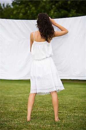 simsearch:877-06832290,k - Young woman hanging a white sheet, oudoors Stock Photo - Rights-Managed, Code: 877-06832348