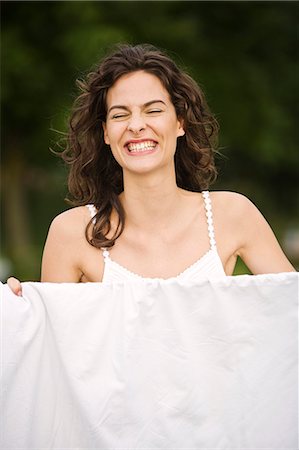 simsearch:877-06832290,k - Young woman smiling, in front of a white sheet, oudoors Stock Photo - Rights-Managed, Code: 877-06832343