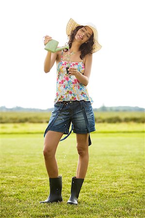 simsearch:877-06832290,k - Young woman watering plant, oudoors Stock Photo - Rights-Managed, Code: 877-06832356