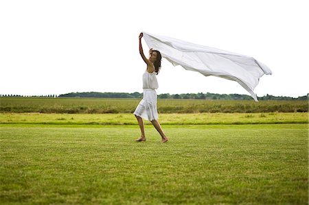 simsearch:877-06832290,k - Young woman walking and holding a white sheet, oudoors Stock Photo - Rights-Managed, Code: 877-06832351