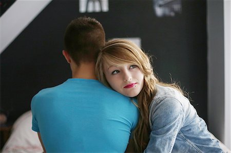 A teenager girl posing with her boyfriend in her room, he is of back, she is thinking Stock Photo - Rights-Managed, Code: 877-08079200