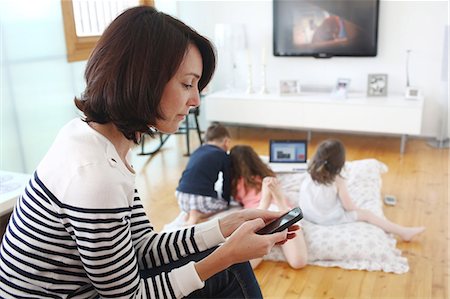 sister feet - Family using different electronic devices in their living room Stock Photo - Rights-Managed, Code: 877-08129217