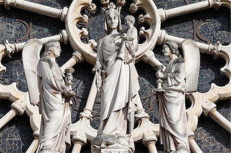 Notre Dame de Paris cathedral. Western facade. In front of the Rose window. Crowned Virgin and child surrounded by two angels. France. Stock Photo - Rights-Managed, Code: 877-08129561