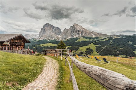 dolomiti - Alpe di Siusi/Seiser Alm, Dolomites, South Tyrol, Italy. View from the Alpe di Siusi to the peaks of Sassolungo/Langkofel and Sassopiatto / Plattkofel with Rauch Hutte on the left Stock Photo - Rights-Managed, Code: 879-09020787