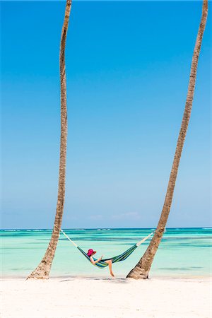 Juanillo Beach (playa Juanillo), Punta Cana, Dominican Republic. Woman relaxing on a hammock on a palm-fringed beach (MR). Foto de stock - Con derechos protegidos, Código: 879-09021021